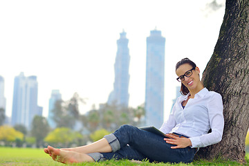 Image showing Beautiful young woman with  tablet in park