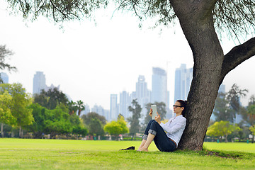 Image showing Beautiful young woman with  tablet in park