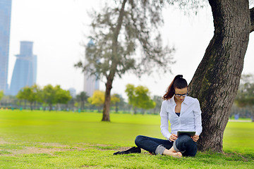 Image showing Beautiful young woman with  tablet in park