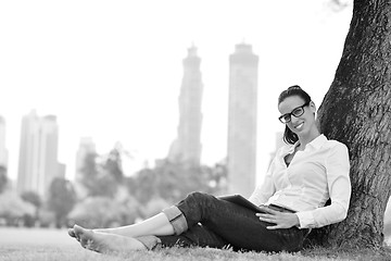 Image showing Beautiful young woman with  tablet in park