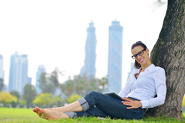 Image showing Beautiful young woman with  tablet in park