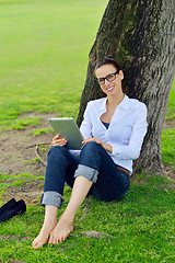 Image showing Beautiful young woman with  tablet in park