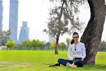 Image showing Beautiful young woman with  tablet in park