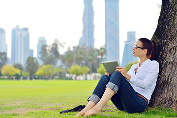 Image showing Beautiful young woman with  tablet in park