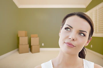 Image showing Young Woman Daydreaming in Empty Room with Boxes