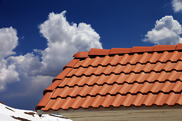 Image showing Roof tiles and blue sky with clouds