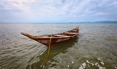 Image showing Empty old wooden boat on the waves