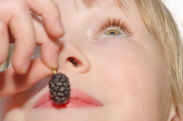 Image showing Girl holding and eating mulberry fruit