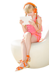 Image showing Girl with tablet PC watching video in headphones isolated