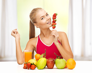 Image showing woman with organic food eating strawberry