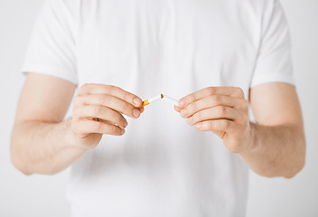 Image showing man breaking the cigarette with hands