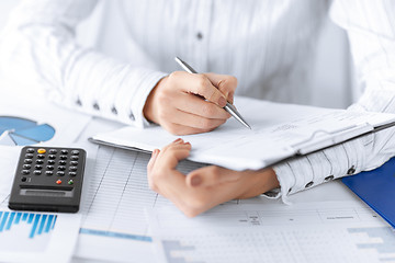 Image showing woman hand with calculator and papers