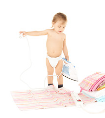 Image showing baby plugging in iron