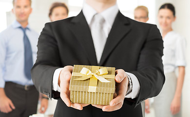 Image showing man hands holding gift box in office