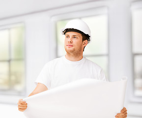 Image showing male architect looking at blueprint at home