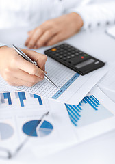 Image showing woman hand with calculator and papers