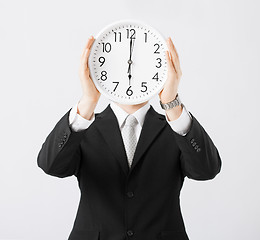 Image showing man with wall clock