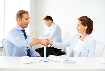 Image showing man and woman shaking hands in office