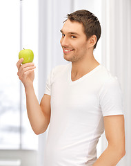 Image showing man in white shirt with green apple