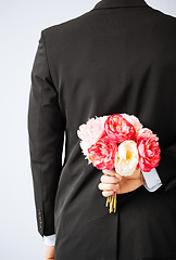 Image showing man hiding bouquet of flowers