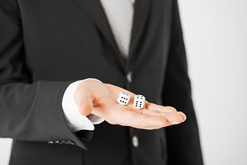 Image showing mans hand holding white casino dice