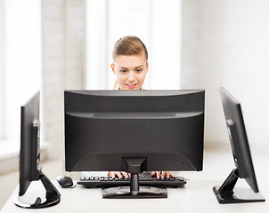 Image showing businesswoman with computer and monitors in office