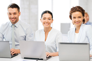 Image showing group of people working with laptops in office