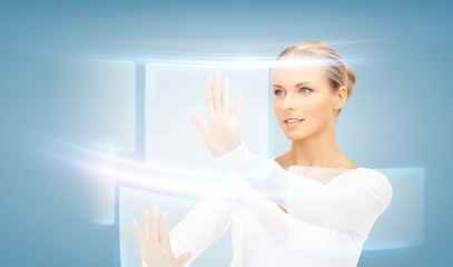 Image showing businesswoman touching virtual screen