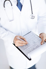 Image showing male doctor holding prescription paper in hand