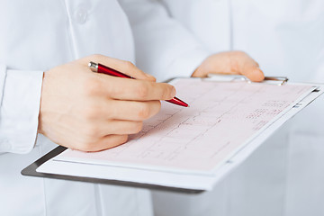 Image showing male doctor hands holding cardiogram