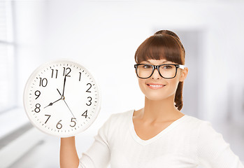 Image showing businesswoman with wall clock