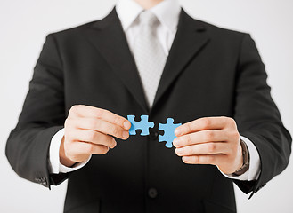 Image showing man trying to connect puzzle pieces