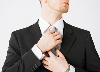 Image showing man adjusting his tie