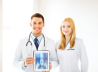 Image showing two doctors showing x-ray on tablet pc