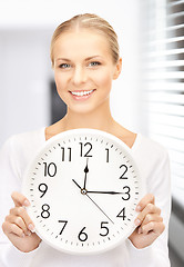 Image showing businesswoman with wall clock