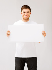 Image showing young man holding white blank board