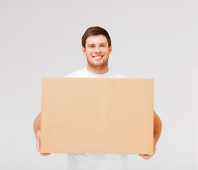 Image showing smiling man carrying carton box