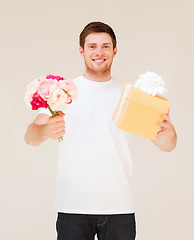 Image showing man holding bouquet of flowers and gift box