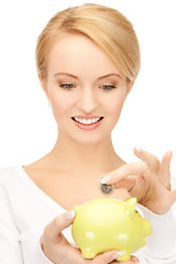 Image showing woman with small piggy bank and coin