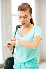 Image showing surprised student girl looking at clock