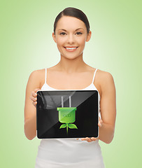 Image showing woman holding tablet pc with green electrical plug