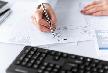 Image showing woman hand filling in invoice paper