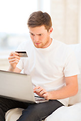 Image showing man with laptop and credit card at home