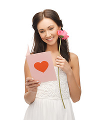 Image showing young woman holding flower and postcard