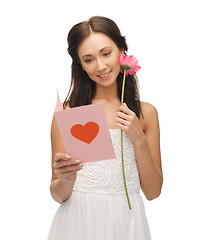 Image showing young woman holding flower and postcard