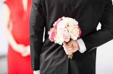 Image showing man hiding bouquet of flowers