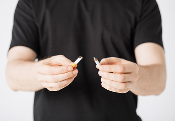 Image showing man breaking the cigarette with hands