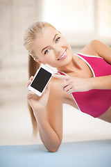 Image showing woman lying on the floor with smartphone