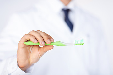 Image showing dentist or stomatologist holding toothbrush