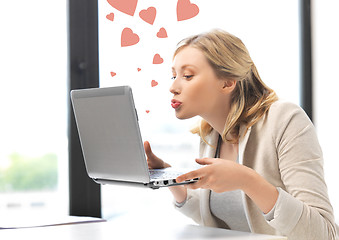 Image showing woman with computer kissing the screen